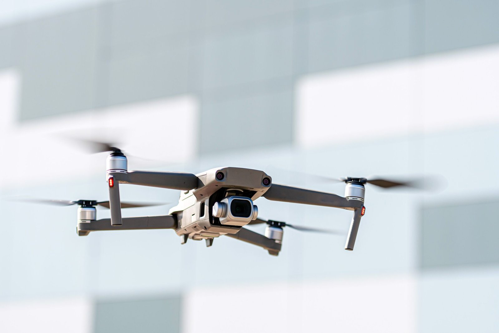 Home drone flying overhead in sky over the roof of the city